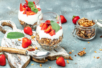Parfait with yogurt, granola, jam, fresh berries and mint leaves in glass jar. gluten free diet, Healthy breakfast. banner, menu, recipe place for text