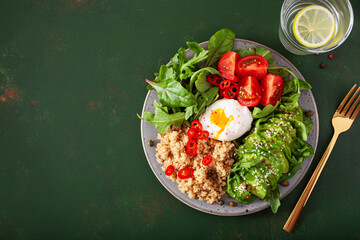 Fototapeta na wymiar quinoa with poached egg, avocado tomato salad leaves. healthy vegetarian lunch breakfast