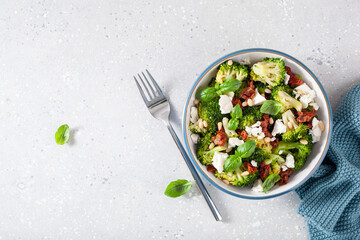 healthy broccoli salad with feta cheese sun dried tomatoes pine nuts. vegetarian low carb keto diet