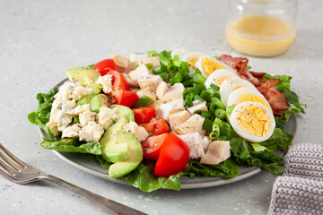 healthy American Cobb salad with egg bacon avocado chicken tomato. hearty keto low carb diet