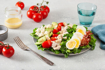 healthy American Cobb salad with egg bacon avocado chicken tomato. hearty keto low carb diet