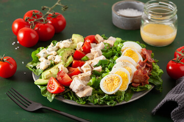 healthy American Cobb salad with egg bacon avocado chicken tomato. hearty keto low carb diet