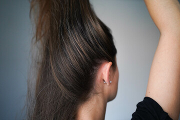 Fototapeta premium Gray hairs on the head of a young girl. Long gray hair. The initial stage of gray hair. The problem of gray hair in women.
