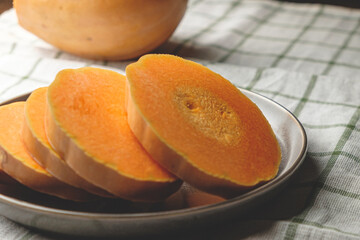 Halloween pumpkin pieces on  ceramic plate ,  pumpkin pieces cut for baked, napkin tissue, on on a...