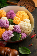 Colorfu cauliflower frame. Cauliflower cut into small pieces in box or basket on old gray stone tile background. Frame mock up. Food cooking and agricultural harvest concept or background.