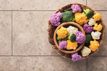 Colorfu cauliflower frame. Cauliflower cut into small pieces in box or basket on old gray stone tile background. Frame mock up. Food cooking and agricultural harvest concept or background.