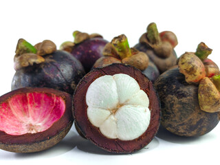 Mangosteen and cross section showing the thick purple skin and white flesh of the queen of friuts, on white background