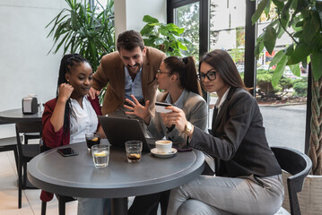 Four young people making their online business for shopping booking and restaurant reservation as internet app service. Friends working on plans and ideas for their new small company.