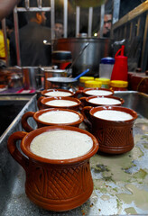 Traditional indian tea set or for serving black tea. Consists of a pot, cups, and a tray made of clay. Isolated, copy space.