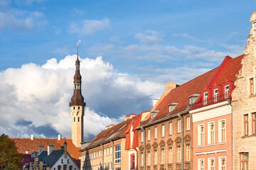 Fototapeta premium Picturesque Tallinn Town Hall tower and close-up on historic facades of ancient medieval buildings. Daytime, blue sky, historical city center of Tallinn, Estonia.