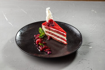 slice of red velvet cake with raspberries on white plate on the table