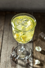 Apple pineapple cocktail with sparkling wine with ice cubes in wine glass on the table
