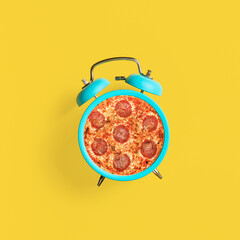 Graphics showing an alarm clock and pepperoni pizza. Time for pizza. Photo on a summer yellow background. Modern food concept. Place for text. - obrazy, fototapety, plakaty