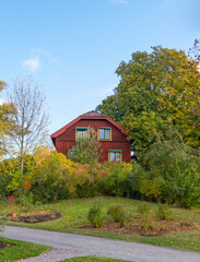 Façade of an old red 1800s house in a park a colorful sunny autumn day in Stockholm