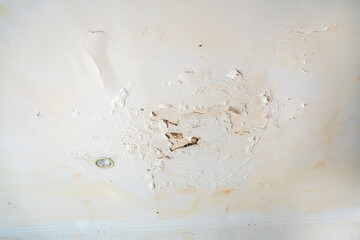 Rain water leaks on the wall causing damage and peeling paint next to some light bulbs - Powered by Adobe