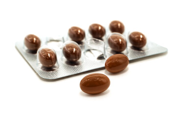 Medical pills capsules of brown color on a white background. Medicinal preparations of plant origin in the form of capsules isolate