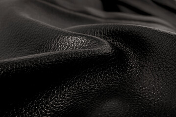 Black leather texture. Abstract background of dark leather with small roughness and scuffs
