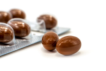 Medical pills capsules of brown color on a white background. Medicinal preparations of plant origin in the form of capsules isolate