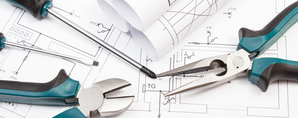 Pliers, screwdriver and diagrams of housing plan with electrical installation. Building home