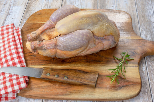 pintade enti&egrave;re en gros plan sur une planche &agrave; d&eacute;couper