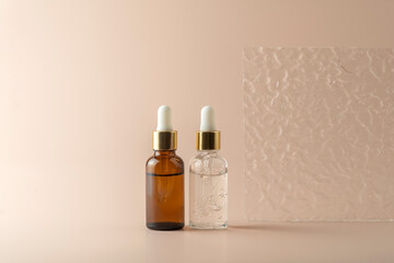 A transparent face serum in dropper bottles or essential oil  or gel standing on a beige background