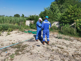 A radiation safety officer (RSO) inspecting radiation dose rate in a farming area around a drilling...