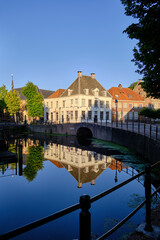 Fototapeta na wymiar Amersfoort, Netherlands - August 09, 2022: Canal house reflections in the Westsingel canal in the historic centre of Amersfoort.