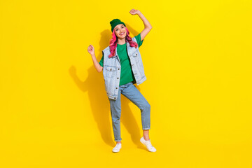 Fototapeta premium Full length photo of cheerful lucky girl dressed denim vest rising fists isolated yellow color background