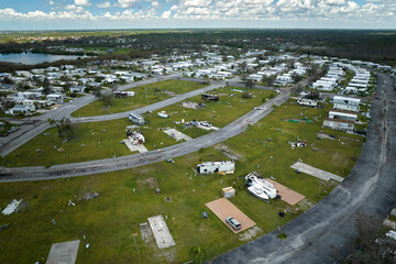 Severely damaged and overturned camper vans and houses after hurricane Ian in Florida mobile home...
