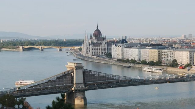Top view of the chain bridge and the parliament building in Budapest near the Danube river. Panoramic view of the famous tourist city. Embankment and ancient historical buildings. Ships float on river