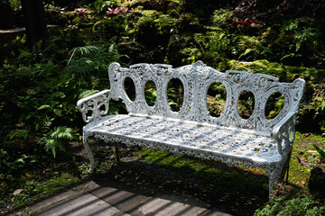 white iron bench in the backyard garden