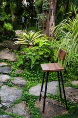 Black steel leg bench in palm garden to relax
