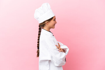 Little caucasian chef girl isolated on pink background in lateral position