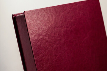 Burgundy leather box for a photo book on a light background.