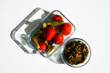 pickled tomatoes and cucumbers with seaweed in a glass container