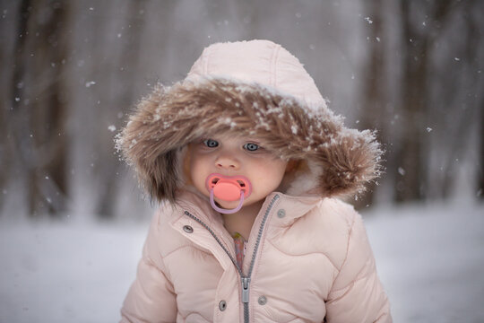 Female Young Child Outdoors With Pacifier In Winter Wearing A Pi