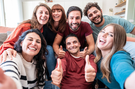 Group of friends having fun at home while taking selfie
