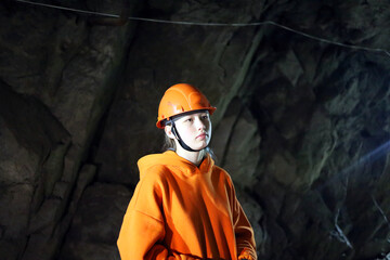 Teenage girl in a helmet in a cave