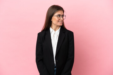 Young Business caucasian woman isolated on pink background looking to the side and smiling