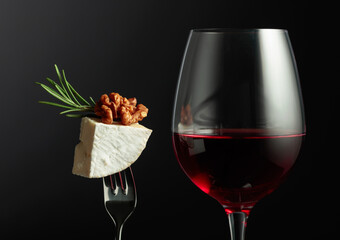 Glass of red wine and Camembert cheese with rosemary.