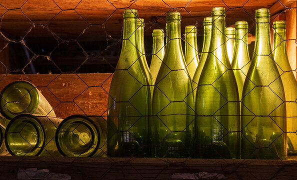 Alte und leere Weinflaschen in einem verstaubten Weinregal