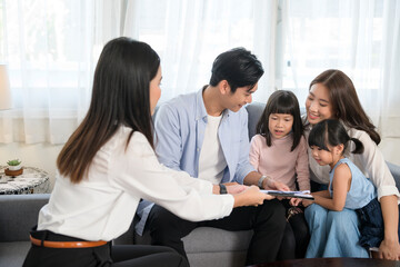 Asian family meeting with female real estate agent or insurance consultant offering promotions , Mortgage, loan, property and medical health insurance concept.