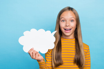 Portrait of cheerful positive school girl dressed yellow long sleeve hold white dialogue cloud...