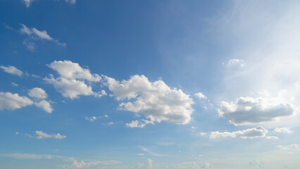 Naklejka na ściany i meble Clear blue sky with white fluffy clouds. Nature background