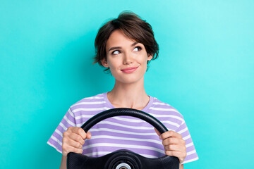 Portrait of lovely nice girl with bob hairdo wear striped t-shirt hold steering wheel look empty space isolated on teal color background