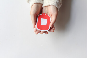 hand holding bloody bag shape made from paper on white background, copy space, top view. blood...