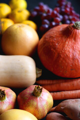 Various fresh and healthy autumnal fruit and vegetable. Selective focus, dark background.