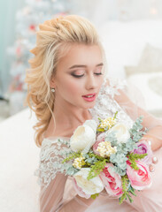 Obraz na płótnie Canvas Beauty fashion bride in interior studio with bouquet of flowers in her hands. Beautiful Bride portrait wedding makeup and hairstyle. Fashion bride model in luxury wedding dress.