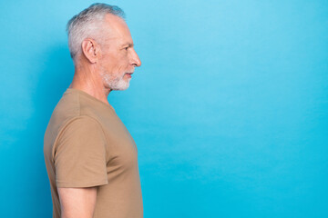 Side profile photo of positive senior pensioner gray hairstyle stubble beige t-shirt look empty...