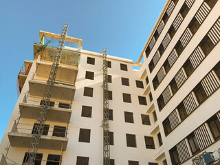 residential building under construction, with scaffolding mounted on the facade.